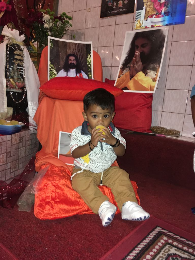 Choosing to eat a fruit prasad while sitting on Mohanji's foot cushion